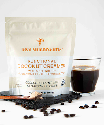 Coconut creamer pouch next to coffee mug and coffee beans