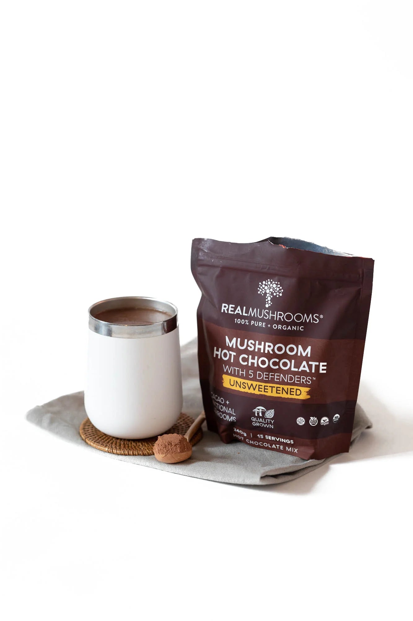 A cup of hot chocolate next to a bag of chocolate.