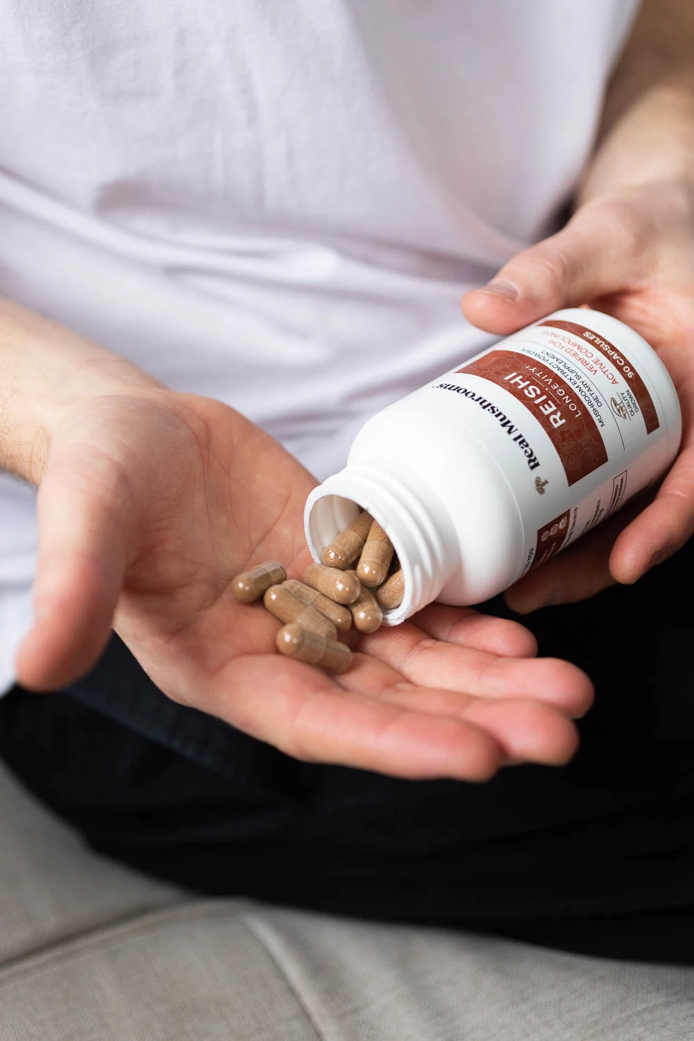 A man holding a bottle of supplements.
