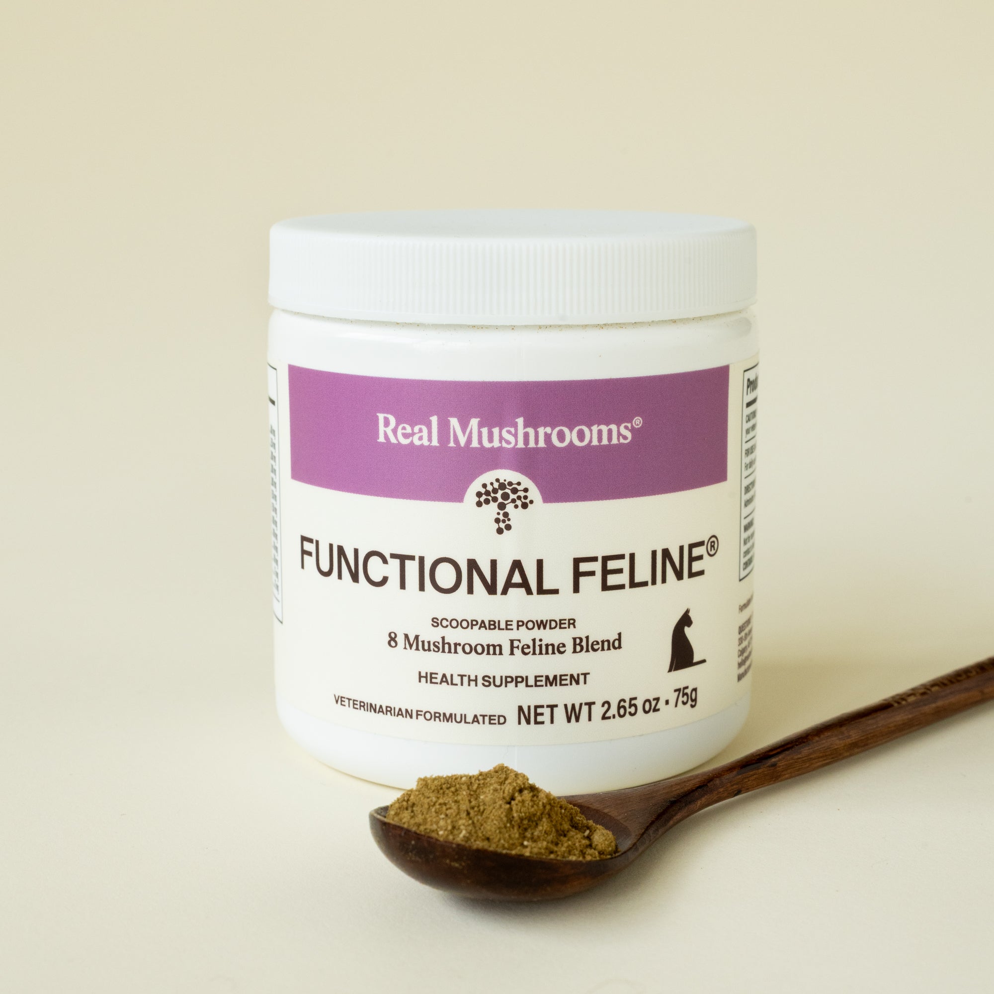A container of Real Mushrooms Functional Feline® Powder for Cats is placed next to a wooden spoon filled with the mushroom supplement powder for cats.