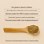 A wooden spoon with Real Mushrooms Lion's Mane with Qrill™Pet powder rests on a beige surface, beside text highlighting its organic ingredients and cognitive health benefits for pets.