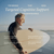 A smiling older man holds a surfboard on the beach. Text highlights the benefits of Real Mushrooms’ Clarity & Vitality Bundle for targeted cognitive support, enhanced mental function, and natural energy—backed by research.