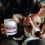 A person holds a container of Real Mushrooms Mushroom Mobility Pet Chews, a hip and joint supplement for pets, while petting a small brown and white dog.