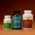 The Real Mushrooms Daily Calm Trio—ERGO+, Lion’s Mane CALM, and Reishi—is displayed side by side against a brown background, highlighting this wellness supplement set.
