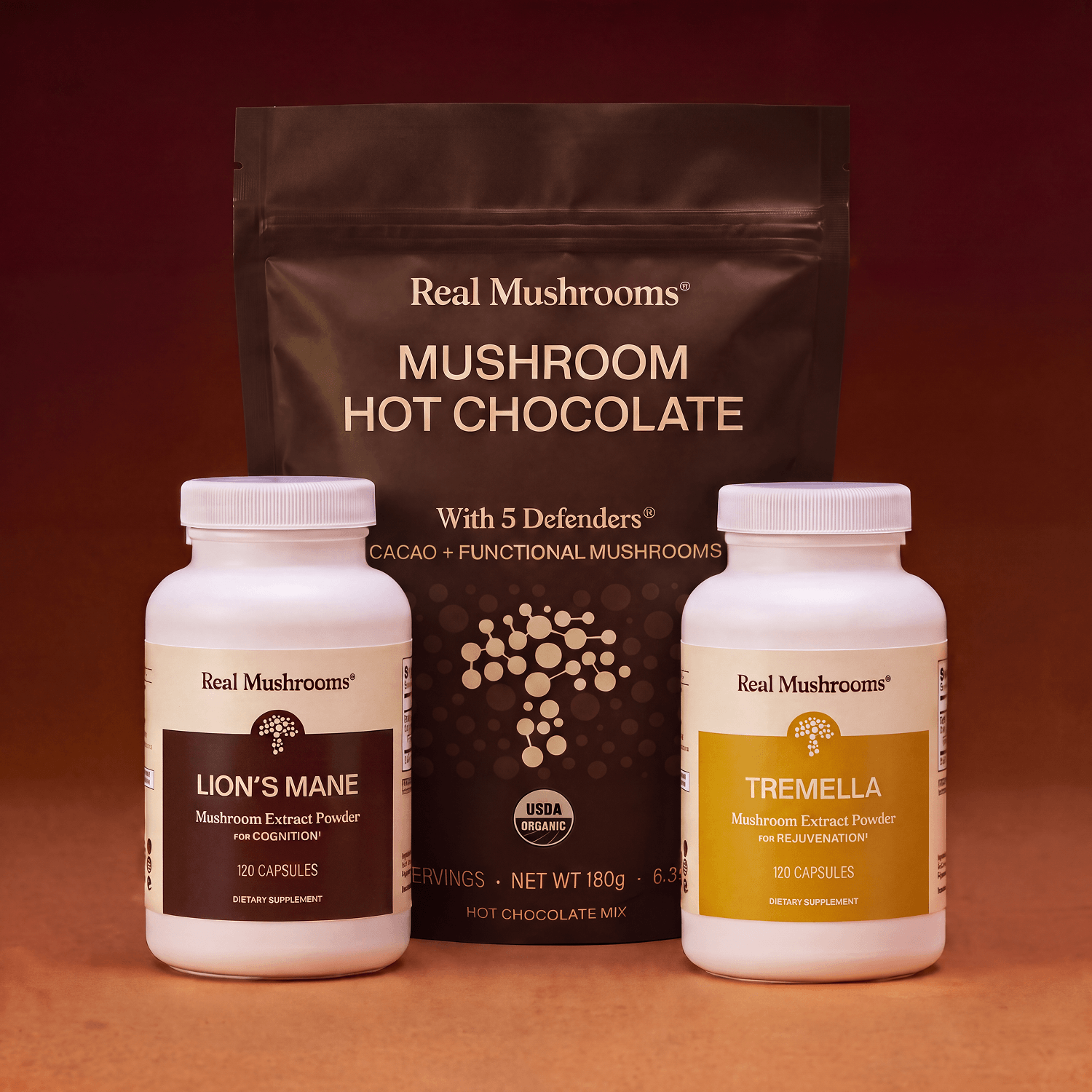 The Real Mushrooms Feel Good Bundle is arranged side by side against a reddish-brown background.