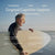 An older man smiles on the beach holding a surfboard. Text promotes cognitive support and research-backed results of Real Mycelium™ by Real Mushrooms, featuring Lion’s Mane with Erinacine A.