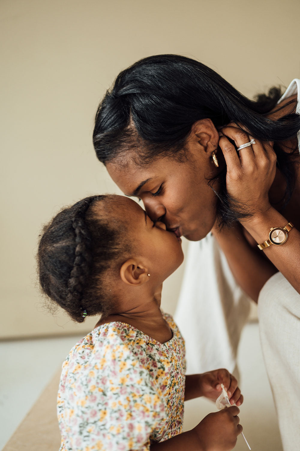 A woman giving her young daughter a kiss