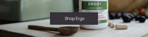 Bottle of Ergo+ mushroom extract powder supplement with a wooden spoon and capsules on a table. Text overlay reads "Shop Ergo - your trusted ergothioneine supplement.