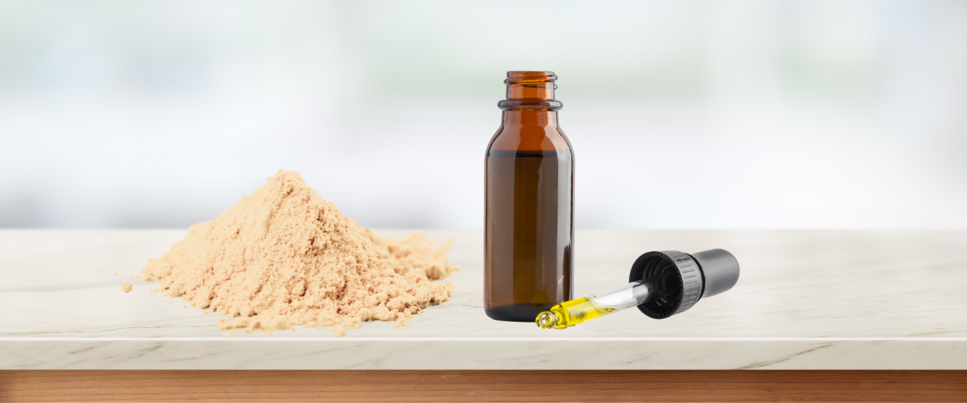 A brown bottle of mushroom supplement tincture with a dropper rests next to a pile of beige powder on a marble surface.