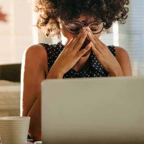 woman working on computer experiencing stress