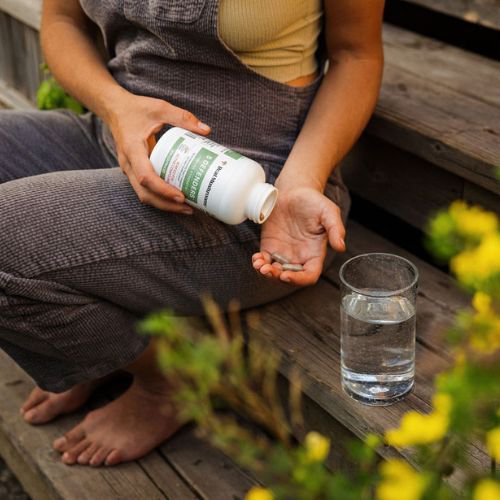 woman with handful of mushroom supplement capsules